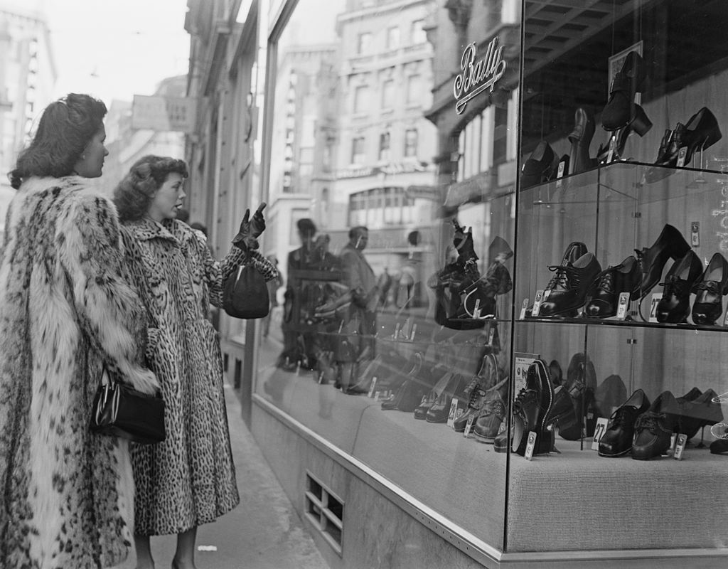 Dos jóvenes admiran el escaparate de una zapatería. Foto: Archivio Cameraphoto Epoche/Getty Images